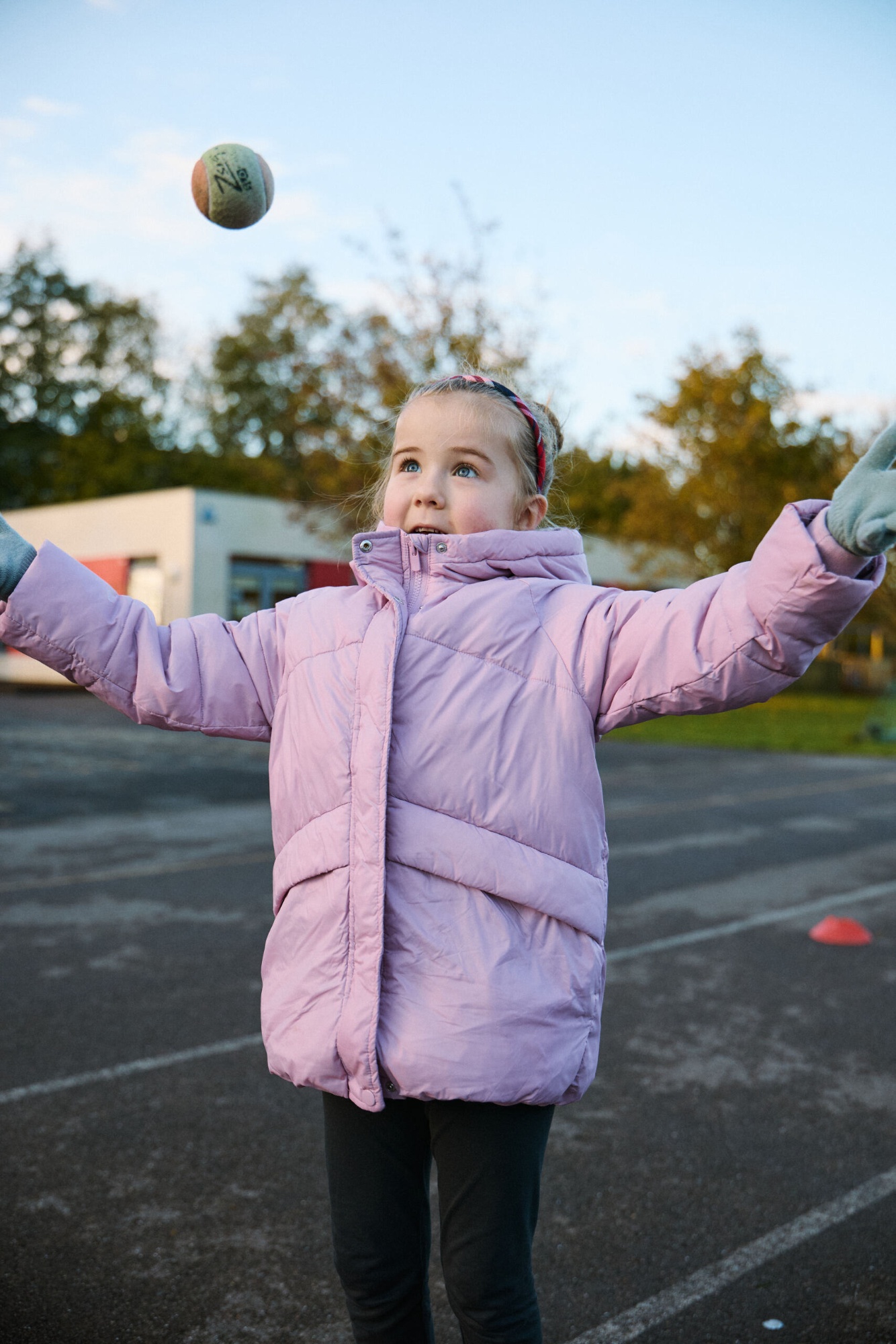 Girl throwing a ball in the playground